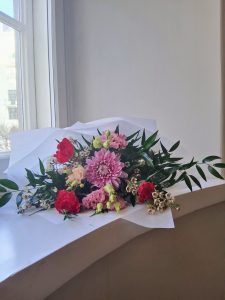 Vaaleanpunaisista kukista sidottu ystävänpäiväkimppu.